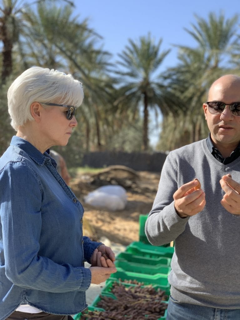 Kathy Smith learning about dates with Karim Boujbel on a farmer video shoot in Tunisia